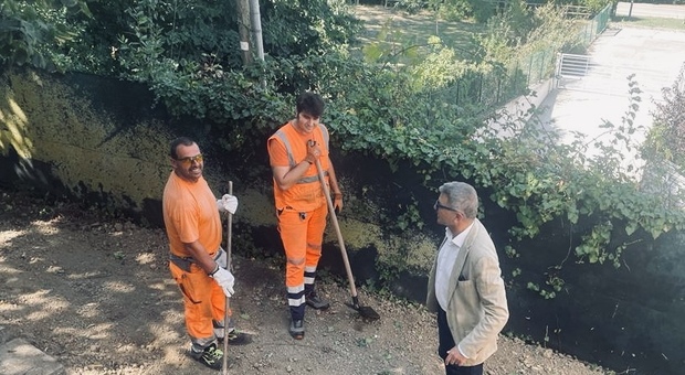 Il presidente dell'Aspe Luca Pieri con due operatori del verde nel giardino della scuola per l’infanzia di Trebbiantico