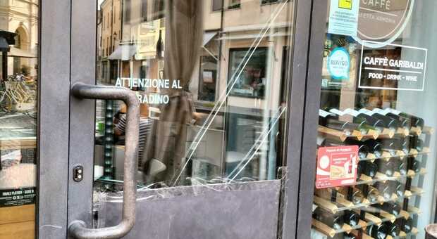 Il vetro della porta del Caffè Garibaldi danneggiato