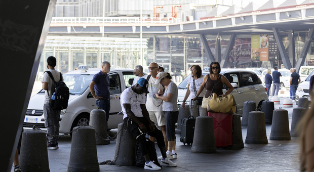 Turisti in attesa di prendere posto su un taxi al parcheggio della stazione in piazza Garibaldi,