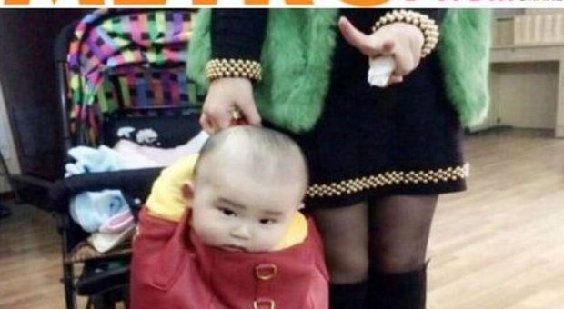 Mette il figlio nella borsa e posta la foto sul web: social in rivolta contro una mamma cinese