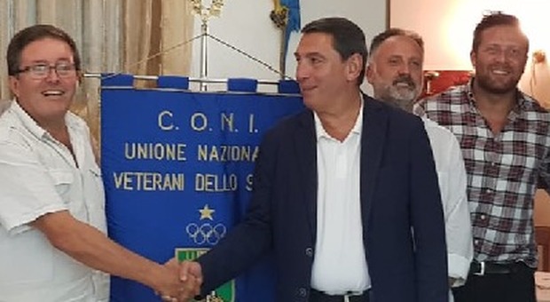 Al centro il presidente uscente stringe la mano a Gigi Bignotti