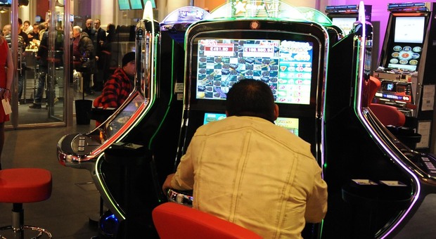 Un cliente di una sala giochi con le slot machine