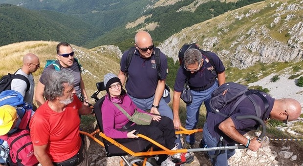 Donna disabile sogna di scalare la montagna e i poliziotti la portano in carrozzina fino a quota 2.108 metri