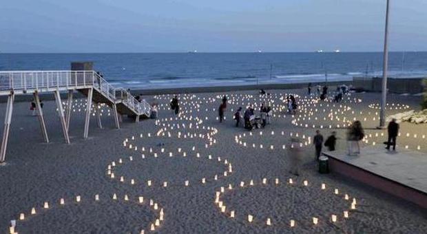 Cerchi di candele e sabbia per un'opera fatta di luce