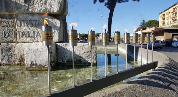 Le fiaccole intorno alla fontana monumento ai paracadutisti di Paolo Caccia Dominioni, a piazza dei Caduti