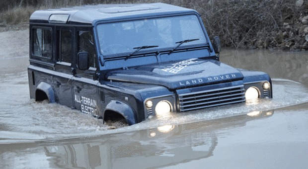 Una Land Rover Defender impegnata ad attraversare un profondo guado