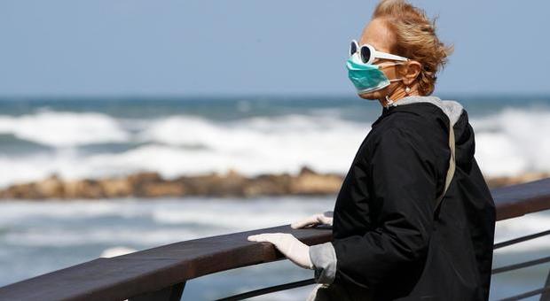 Una donna con mascherina sul lungomare di Tel Aviv