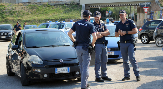 La polizia accanto all'auto rubata usata dai malviventi per la fuga