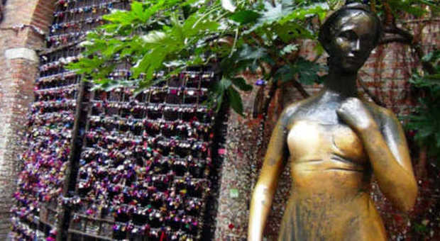 La statua di Giulietta e i lucchetti dell'amore sullo sfondo