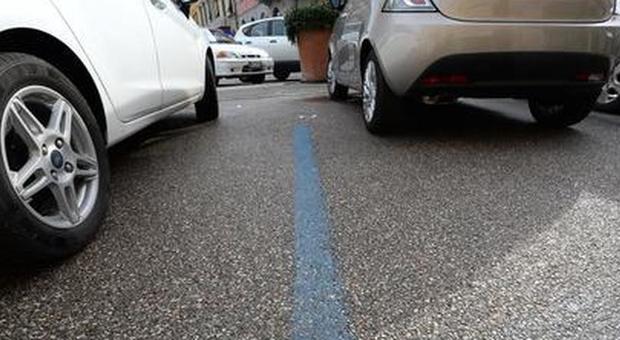 Dipinge di bianco le strisce blu: «Parcheggio offerto da Smartis»