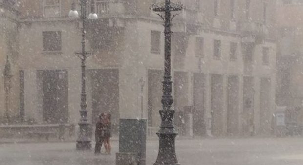 Lecce, il bacio degli innamorati sotto la pioggia