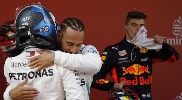 Lewis Hamilton abbraccia il compagno di squadra Bottas, sullo sfondo Verstappen