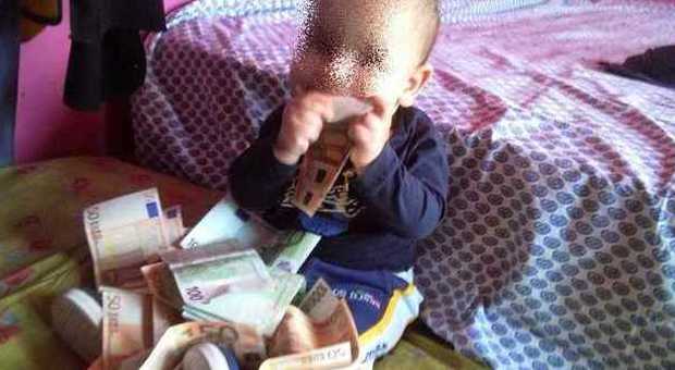Il neonato fa il bagno nelle banconote (Facebook)