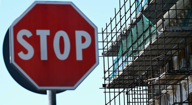 Un cartello di stop e le impalcature per la ristrutturazione edilizia al 110%