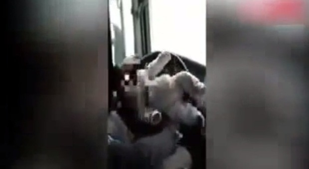 Lega il figlioletto neonato al volante durante la guida: il video choc indigna il web