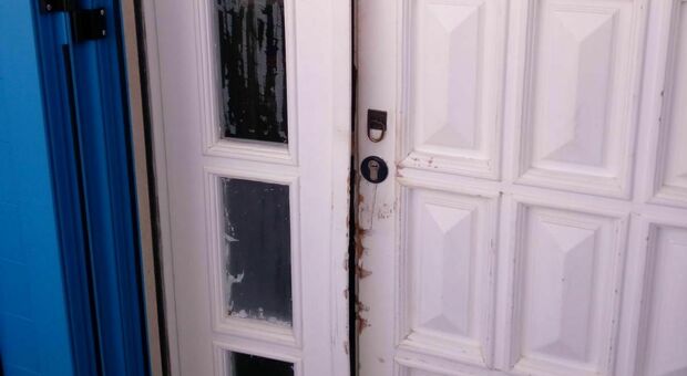 La porta d'ingresso della casa con evidenti segni di effrazione