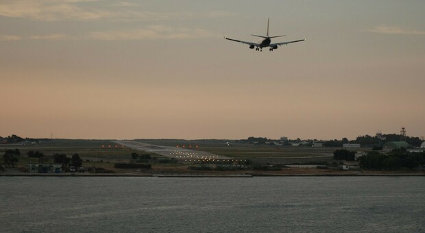 Un aereo che atterra sulla pista dell'aeroporto di Brindisi dopo avere sorvolato il porto