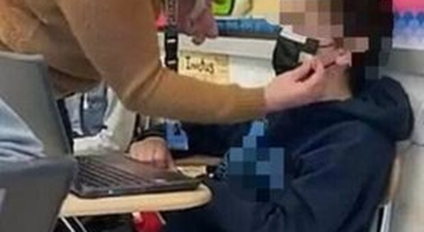 L'immagine di un'insegnante che fissa la mascherina di uno studente con del nastro adesivo suscita polemiche negli Stati Uniti