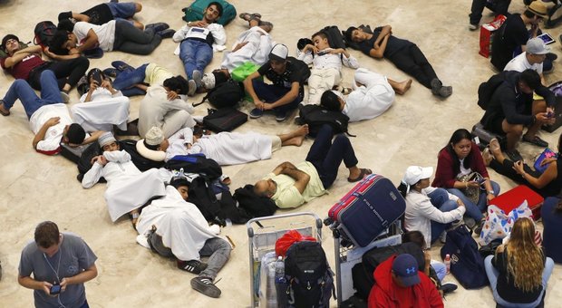 Passeggeri bivaccano all'aeroporto di Manila