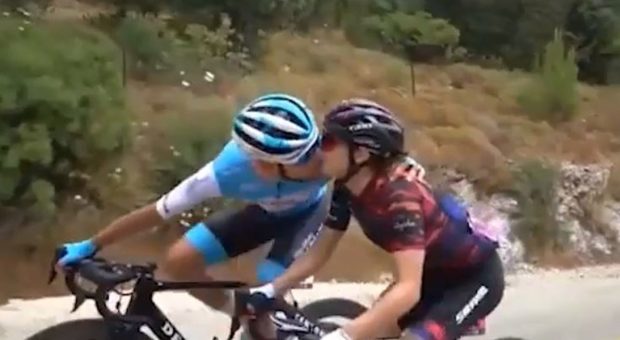 Il ciclista raggiunge la fidanzata in corsa e le dà un bacio prima di tagliare il traguardo: entrambi primi