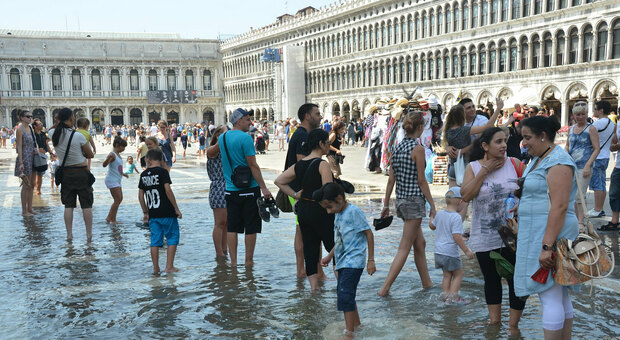 Caldo a Venezia e c'è chi rinfresca nell'acqua alta di piazza San Marco