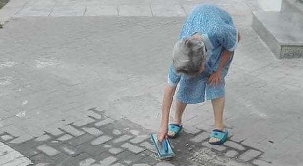 Anziana ripara da sola il marciapiede davanti casa: «L'87enne ha rischiato una multa»