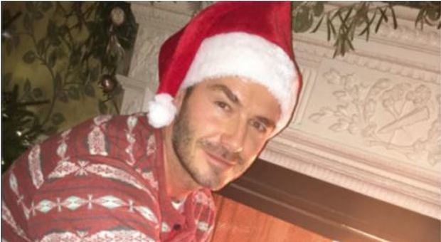 David Beckham sexy Babbo Natale davanti al caminetto: lo scatto in pigiama