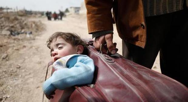 Profughi, un bimbo nella valigia l'immagine della fuga dalla guerra