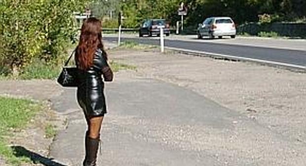 Una prostituta adesca i clienti lungo la strada
