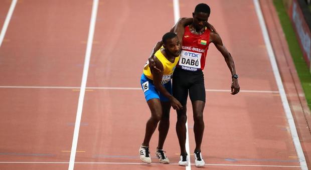 Busby crolla sfinito, Dabó lo prende sotto braccio fino all'arrivo: l'immagine simbolo dei mondiali di atletica a Doha