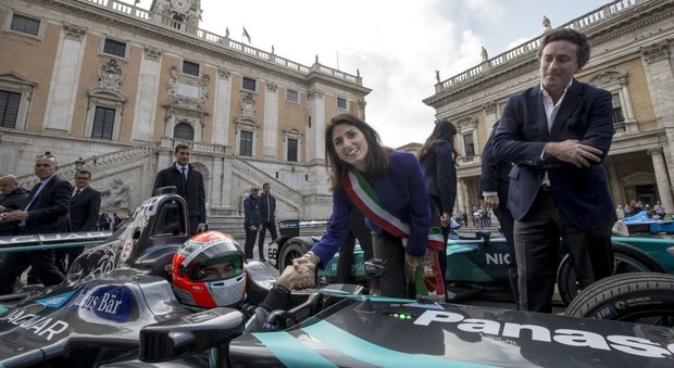 Il sindaco di Roma Virginia Raggi stringe la mano ad un pilota della Formula E sulla piazza del Campidoglio insieme all'ad del campionato elettrico Aleandro Agag