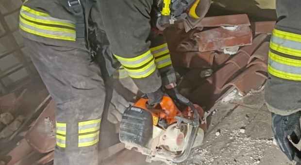 Incendio nel sottotetto: i pompieri si calano nell'intercapedine satura di fumo bollente per rimuovere la guaina