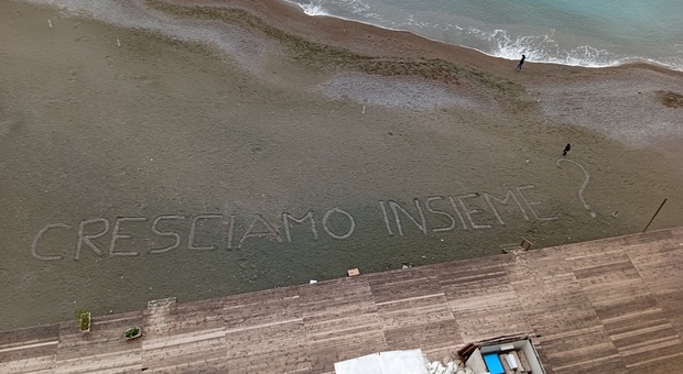 Una scritta sull'arenile metese