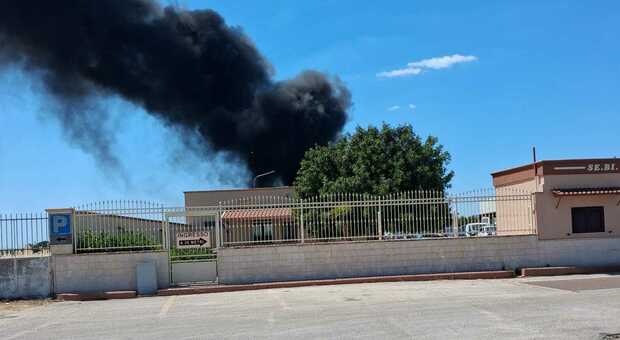 Incendio in un capannone, colonna di fumo nero