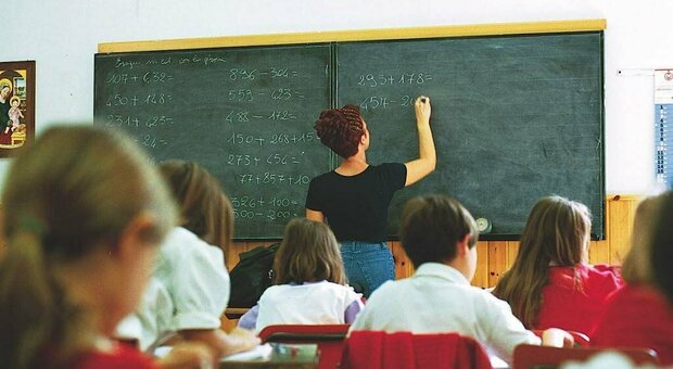 Un insegnante di matematica alla lavagna in una classe di una scuola elementare.