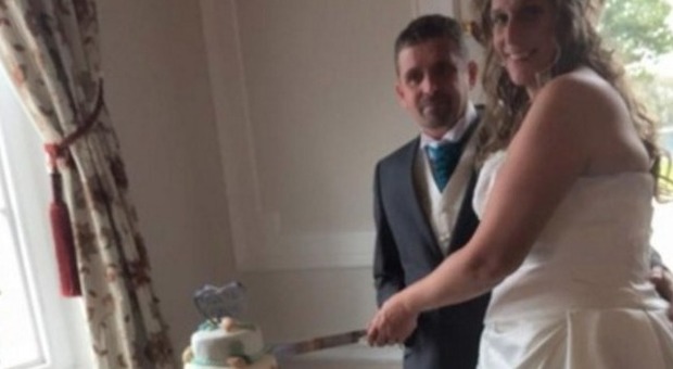 La coppia di sposini taglia la torta nuziale: ma nella foto c'è un dettaglio incredibile... -GUARDA