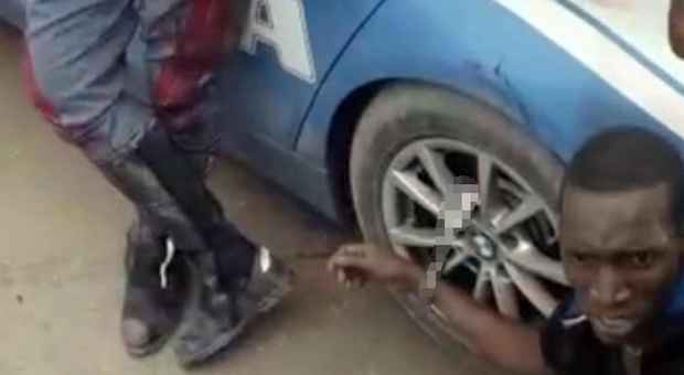 Immigrato gambiano ammanettato alla ruota di una macchina della polizia Video