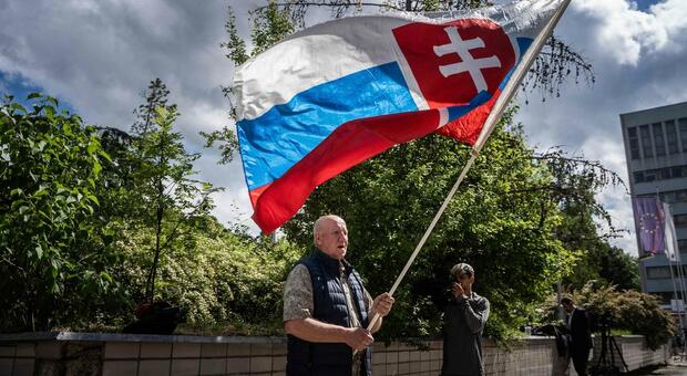 TOPSHOT - Picture taken on May 16, 2024 shows a man named Vladimir Petko holding a Slovakia flag, who came to pray in front of the hospital in Banska Bystrica, Slovakia where Slovak Prime Minister Robert Fico is being treated after he was shot...