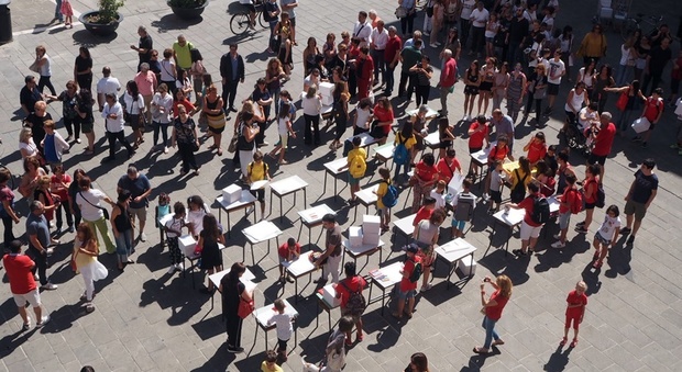 Foligno, attendendo la nuova scuola Carducci gli alunni, i genitori, i docenti e il personale della scuola portano i banchi in piazza della Repubblica