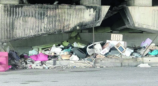Una discarica abusiva sotto il ponte di viale Pasteur: materassi, mobili e copertoni. Rischio incendi per il caldo