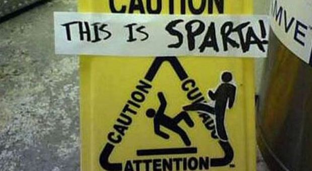 'Questa è Sparta!' su un cartello che indica il pavimento scivoloso
