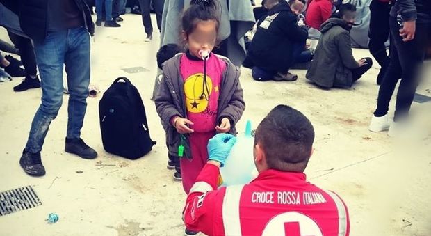 Palloncini con i guanti di lattice e aeroplanini di carta: l'abbraccio della Croce Rossa ai bambini appena sbarcati