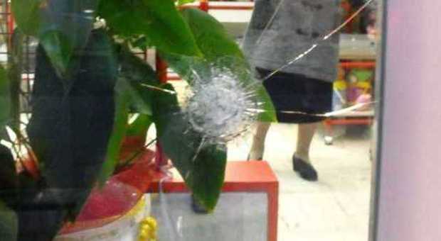 Pietra scagliata da un treno sfonda la vetrina di un negozio