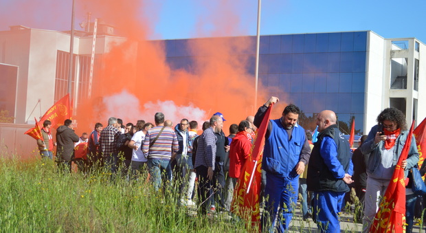 Un fumogeno lanciato dai manifestanti davanti alla sede di Confindustria