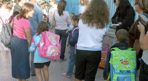 Bambini fuori da scuola insieme ai genitori