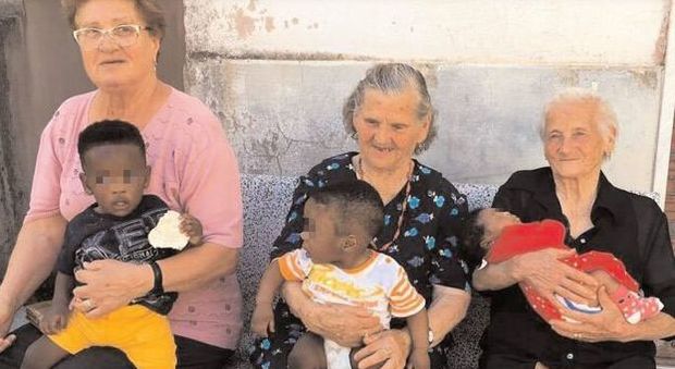Le nonne del paese tengono in braccio tre figli di migranti, la foto diventa virale