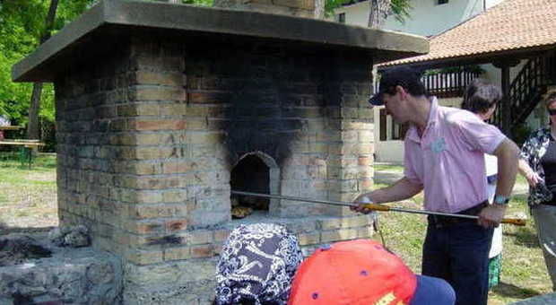 POLCENIGO - Antonio De Fort mentre cucina il pane a San Floriano