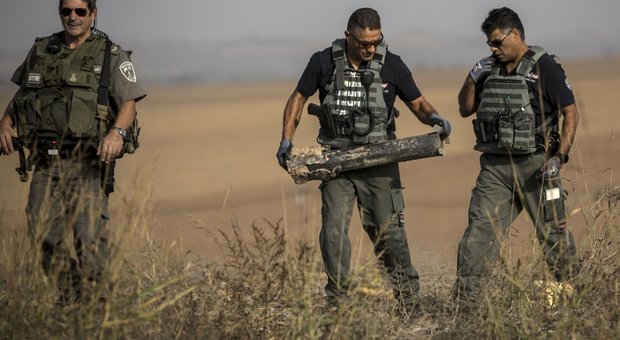 Soldati israeliani con i resti di un razzo sparato dalla Striscia