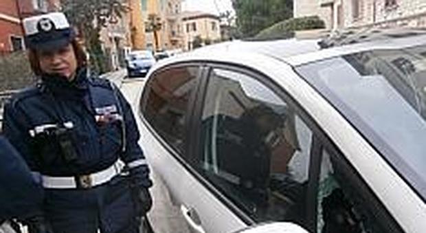 Una vigilessa accanto alla Peugeot 208 rubata in via Ascoli Piceno