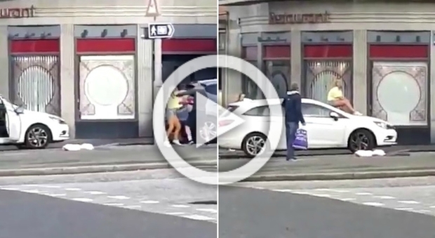 La moglie picchia il marito, lo spoglia e poi si arrampica sul cofano dell'auto